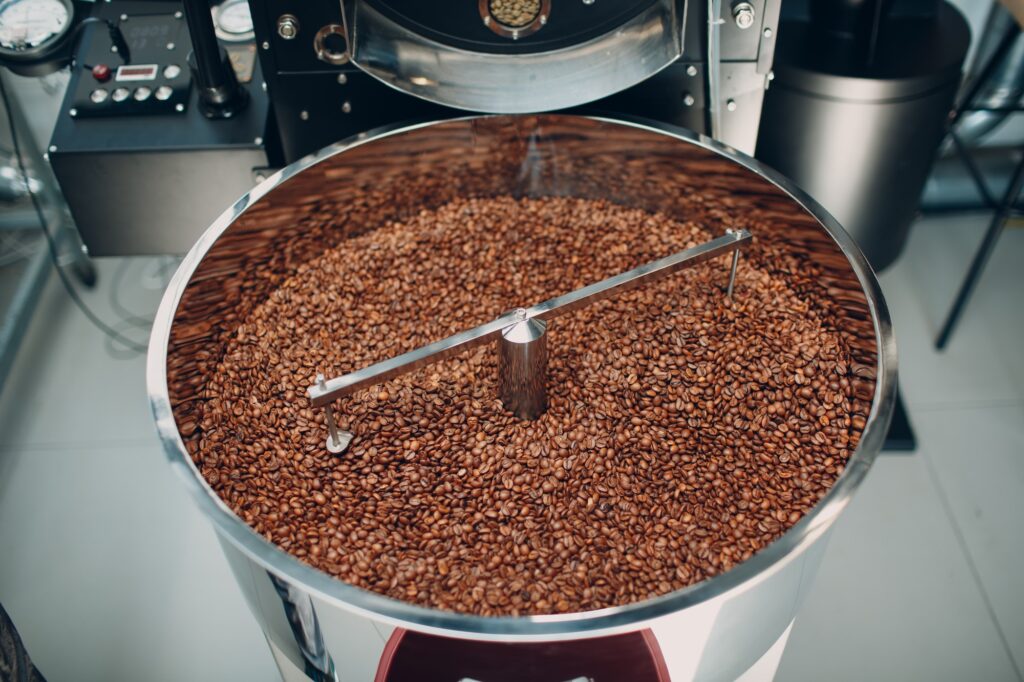 Coffee roaster machine at coffee roasting process. Mixing coffee beans.